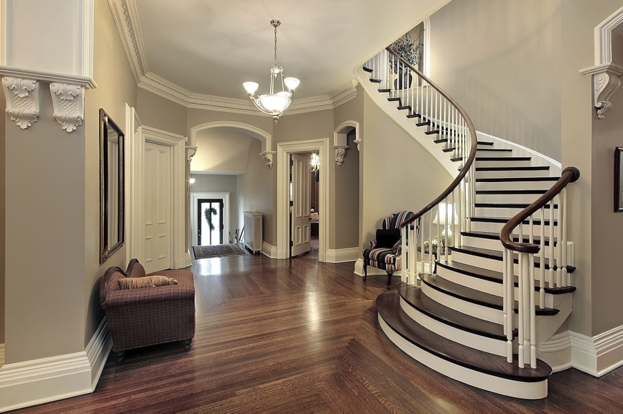 Elegant foyer with curved staircase, hardwood floors, and neutral interior paint colors