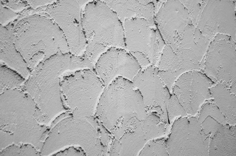 Textured gray plaster wall with overlapping scalloped trowel patterns